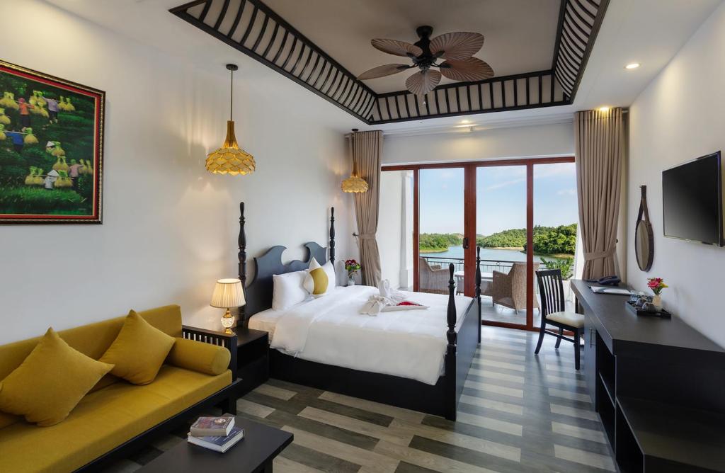 um quarto de hotel com uma cama e um sofá em Phong Nha Lake House Resort em Phong Nha