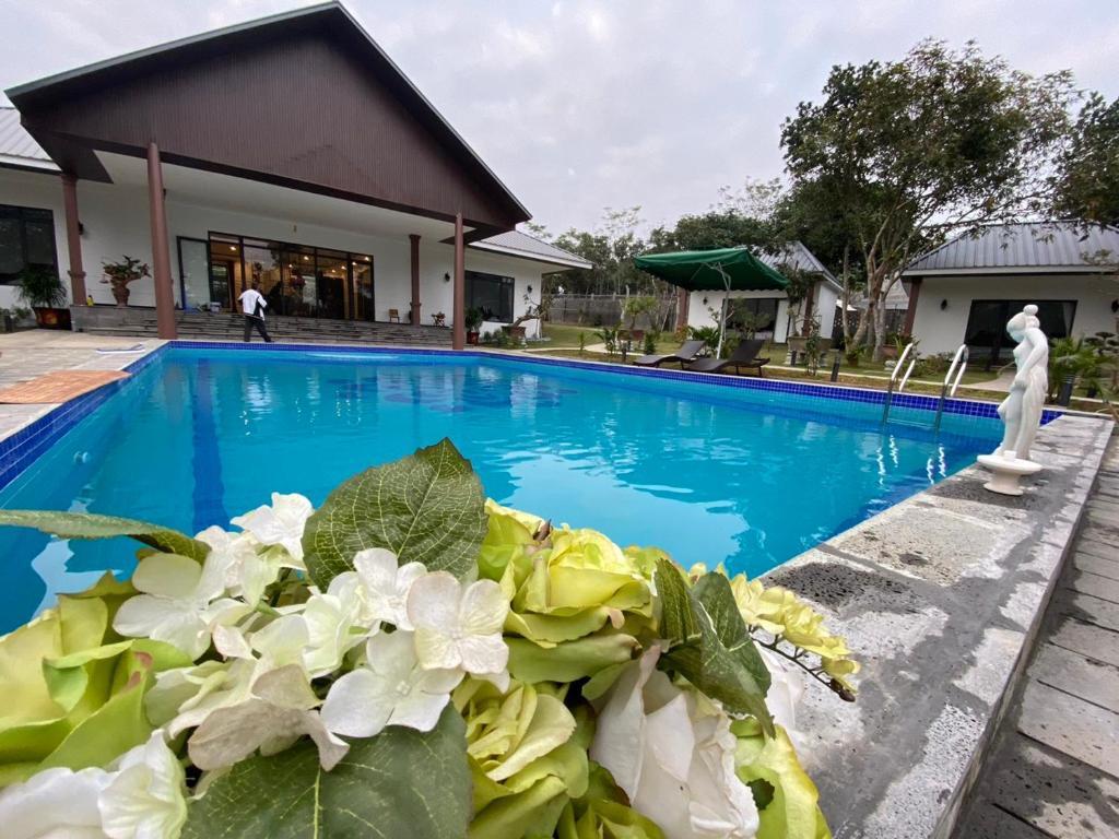 a swimming pool with a statue next to a building at Mít Garden Villas Sơn Tây Venuestay in Sơn Tây