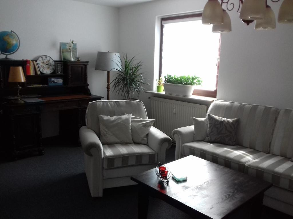 ein Wohnzimmer mit 2 Sofas, einem Tisch und einem Fenster in der Unterkunft Ferienwohnung, Monteurwohnung bis 6 Personen in Rottorf