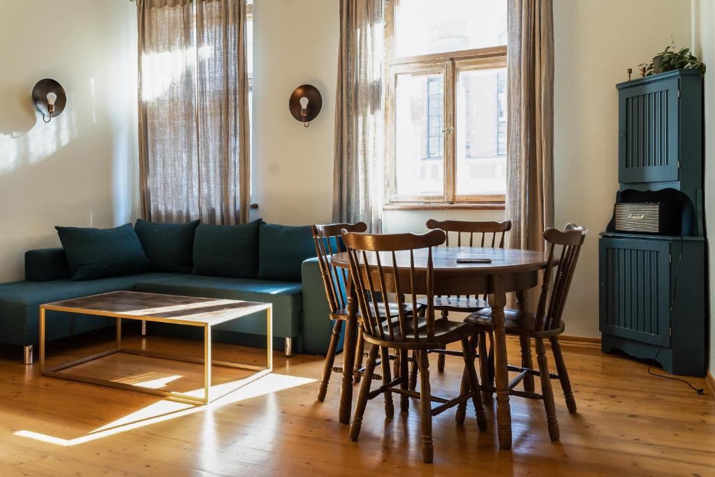 sala de estar con sofá, mesa y sillas en Rakstvežu apartamenti, en Liepāja