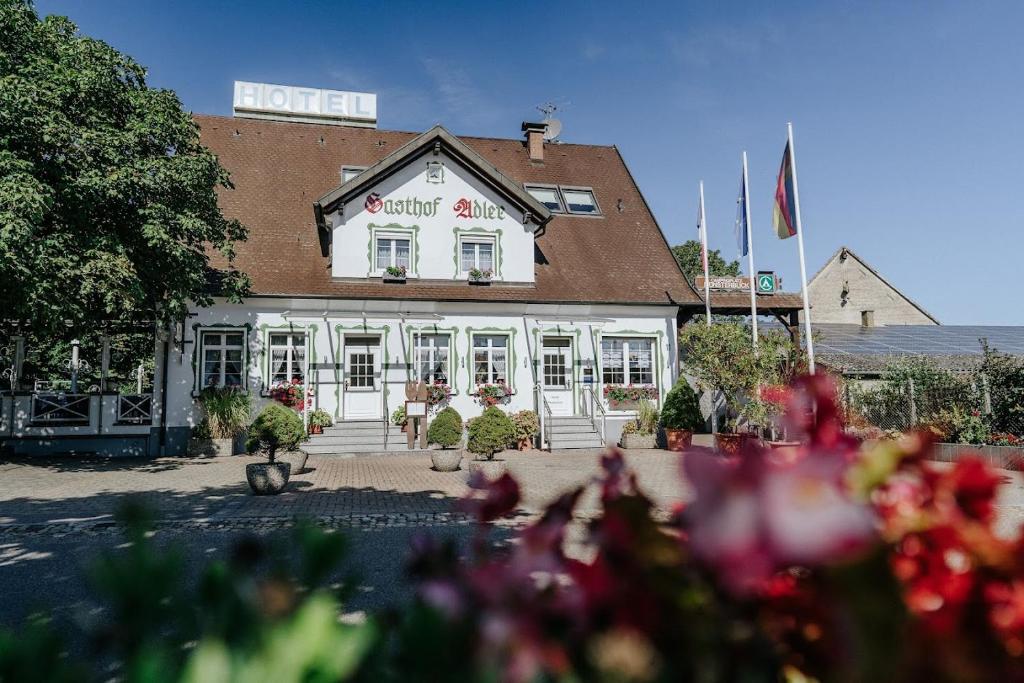 een hotelgebouw met bloemen ervoor bij Landgasthof Adler in Breisach am Rhein