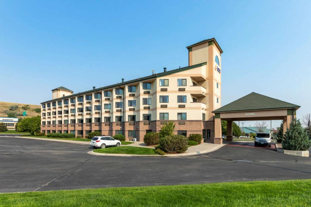 a large building with a car parked in a parking lot at Comfort Inn & Suites Market - Airport in Great Falls