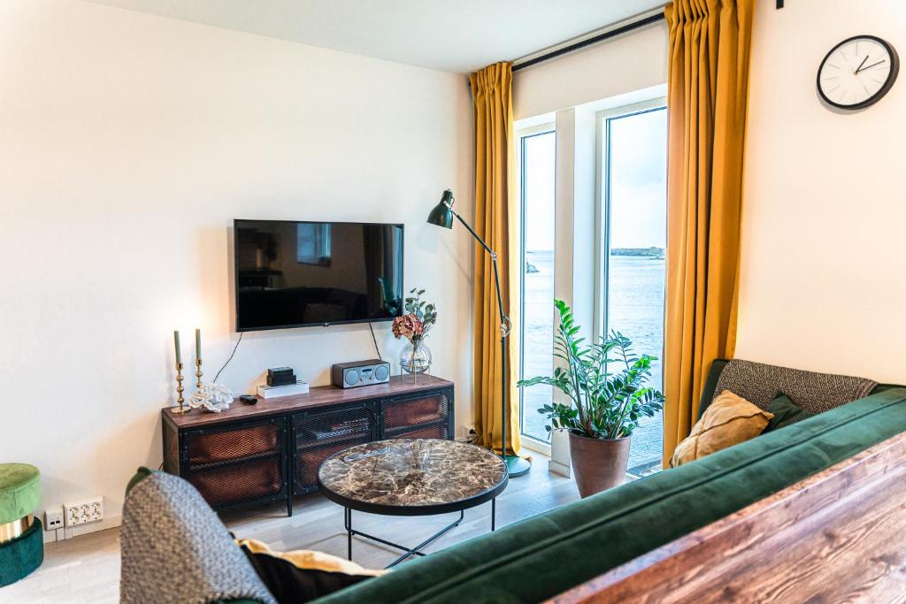 a living room with a couch and a tv at New Åkrahamn coast house in Sæveland
