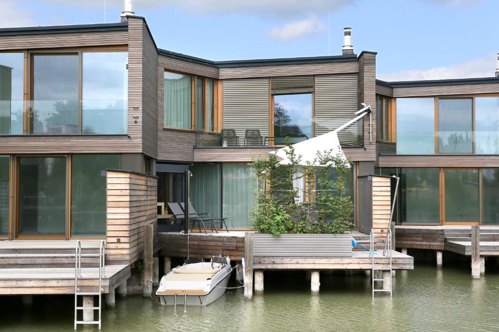ein Haus am Wasser mit einem Dock in der Unterkunft Seehaus SeeZeit - Am Hafen in Neusiedl am See