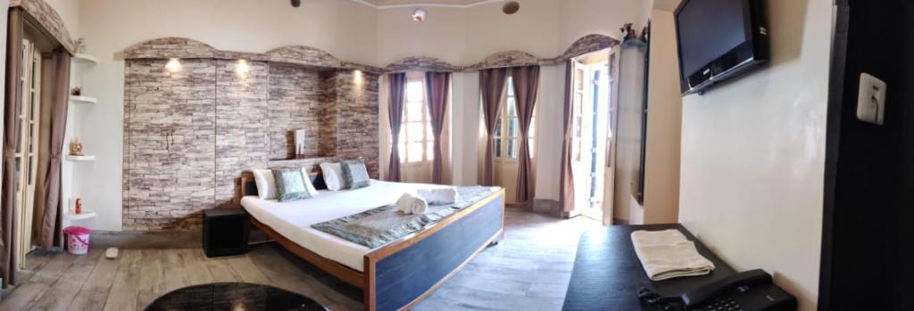 a bedroom with a large bed and a brick wall at Shiva Ganges View Guest House in Varanasi
