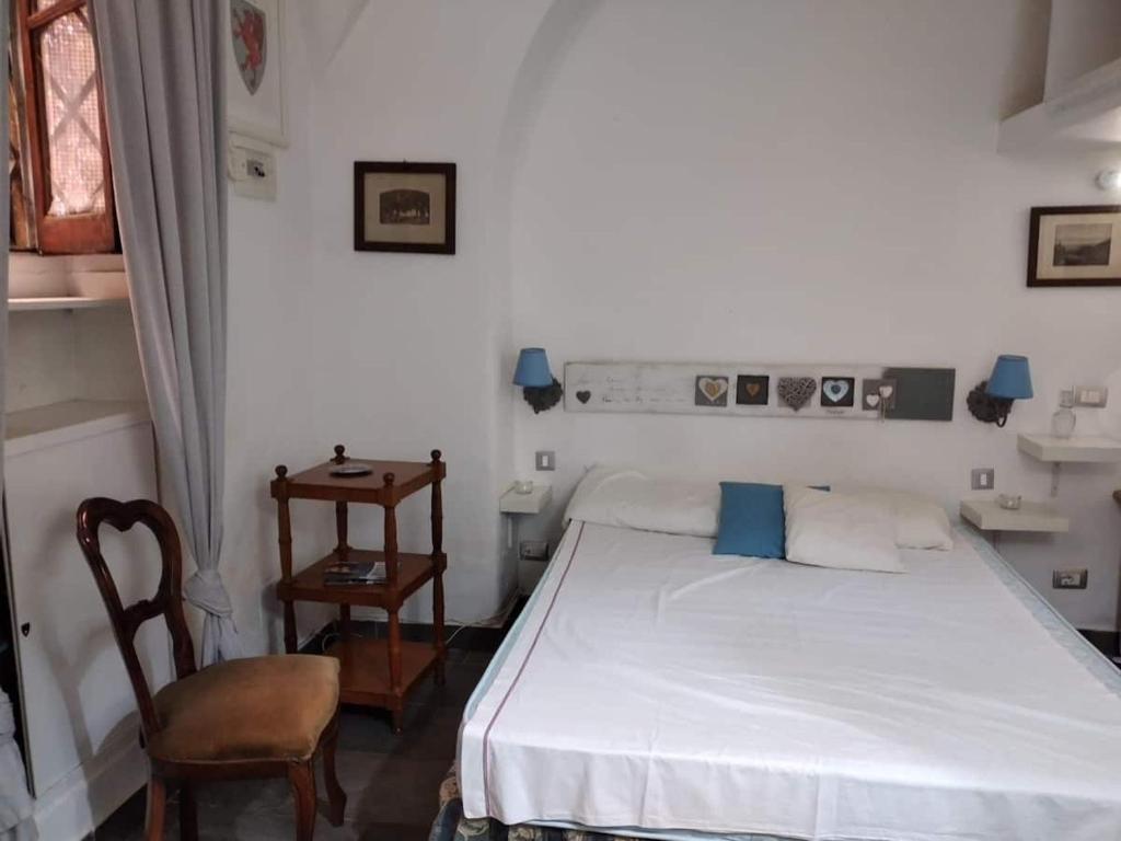 1 dormitorio con 1 cama blanca y 1 silla en Sogno Romano, en Roma