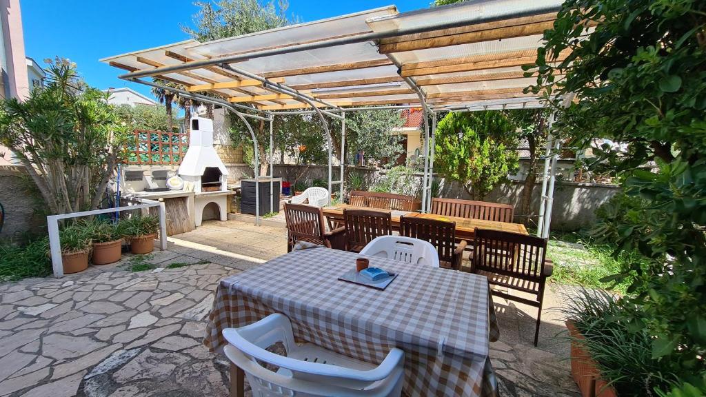 patio ze stołem i krzesłami pod pergolą w obiekcie Tea Nr 1 w Bašce