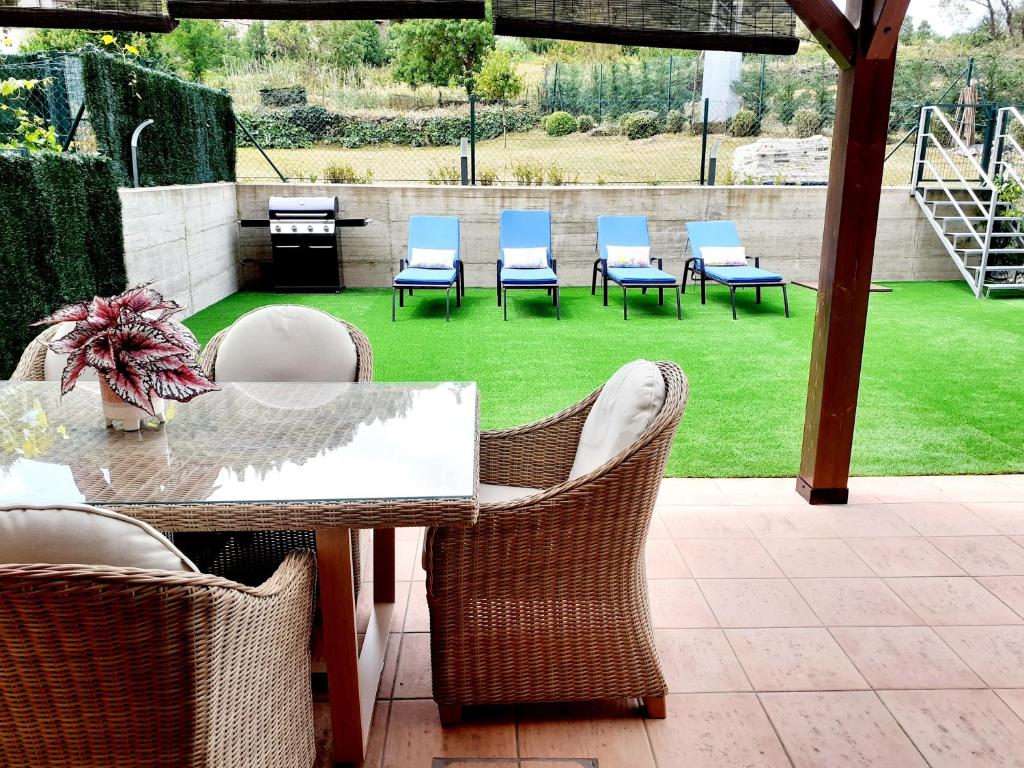 a patio with chairs and a table and a lawn at APARTAMENTO CON JARDÍN MARBLÉS in Ezcaray