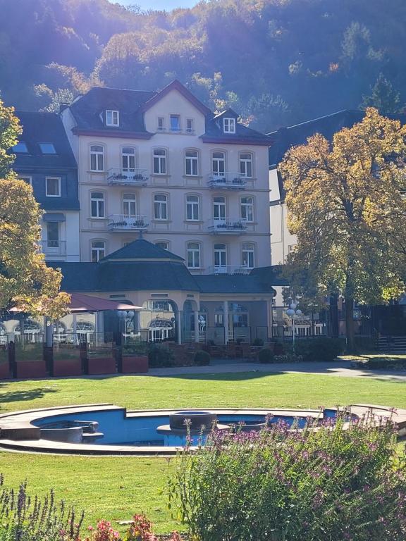 a large white building with a pool in front of it at Vintagehotel Twenty-eight in Bad Bertrich