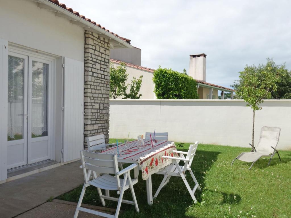 a table and chairs in the yard of a house at Holiday Home La Roquille by Interhome in Pontaillac