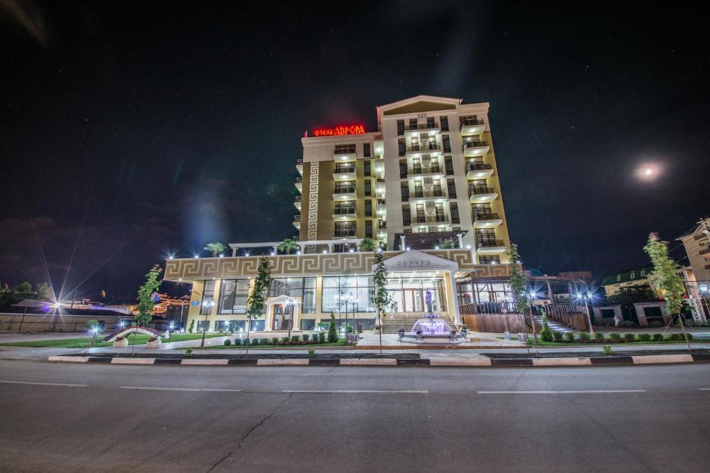 a building with a sign on top of it at night at Hotel Avrora in Vityazevo