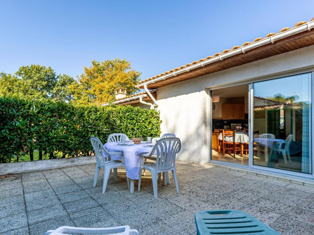 a white table and chairs on a patio at Holiday Home L'Orée des Bois by Interhome in Saint-Georges-de-Didonne