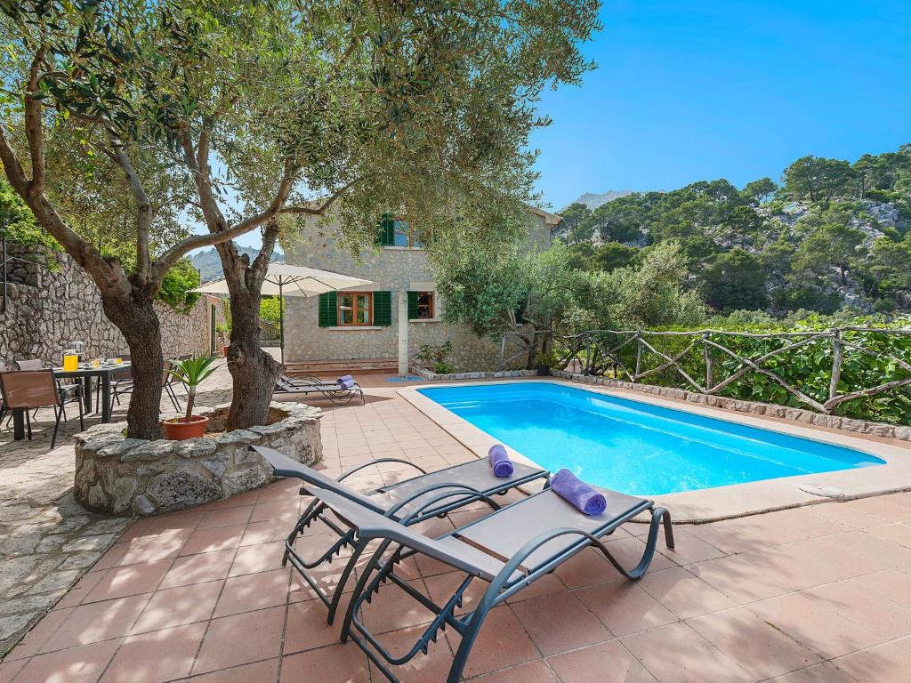 una piscina con una mesa y una silla junto a ella en Holiday Home Es Barracar - CMI105 by Interhome en Caimari