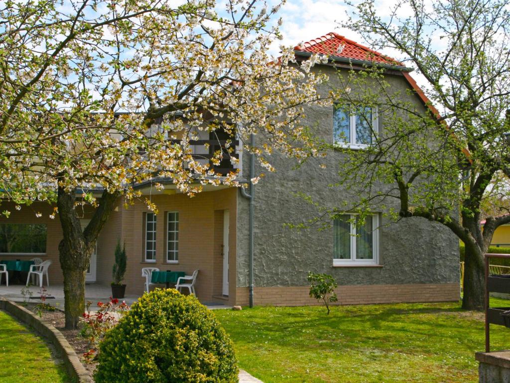 ein Haus mit einem blühenden Baum im Hof in der Unterkunft Holiday Home Zerna by Interhome in Bad Muskau