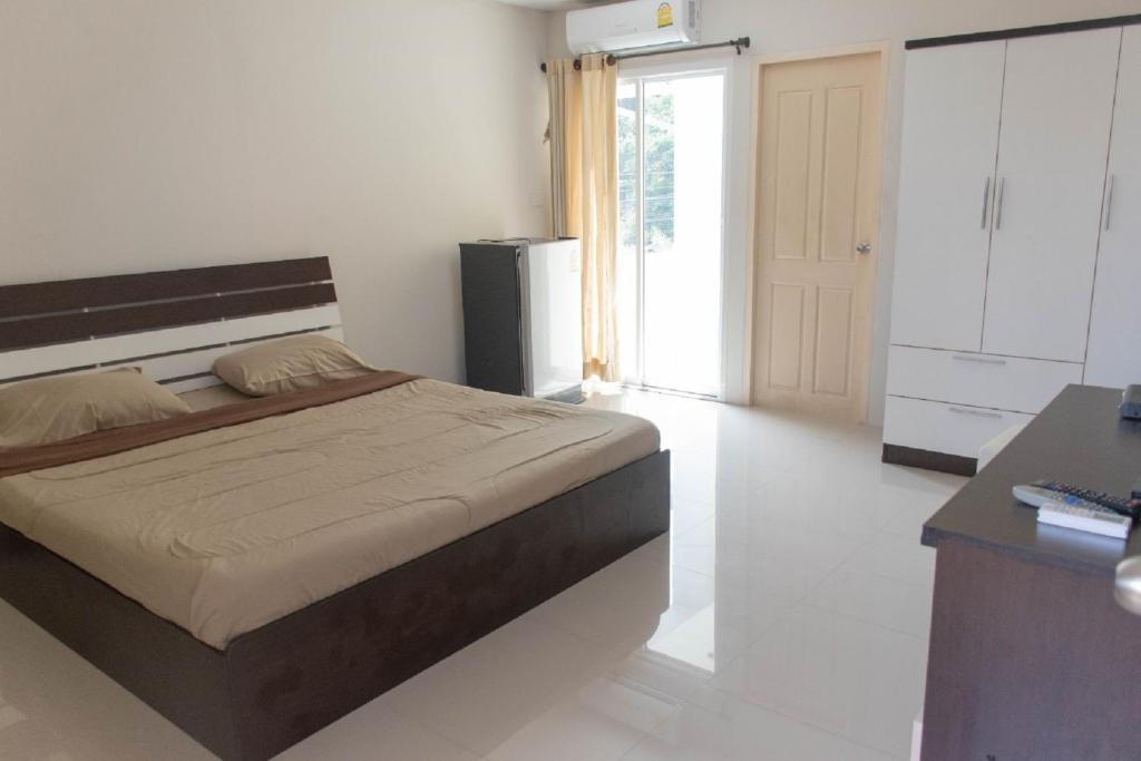 a bedroom with a bed and a desk in it at Suree Place Hostel in Hua Hin