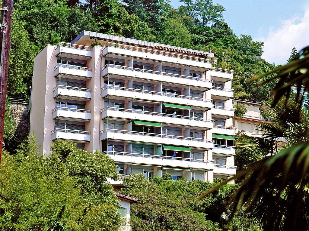 un alto edificio blanco en una colina con árboles en Apartment Castagnola - Utoring-31 by Interhome, en Lugano