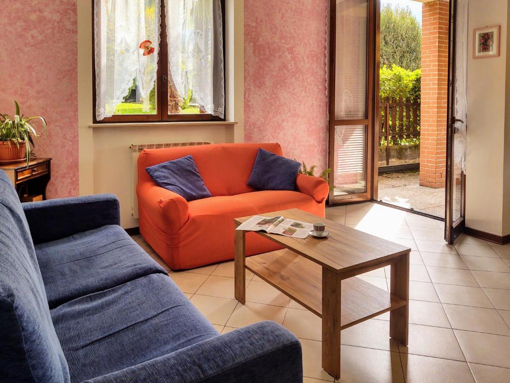 salon z pomarańczową kanapą i stolikiem kawowym w obiekcie Apartment Parco Musadino by Interhome w mieście Porto Valtravaglia