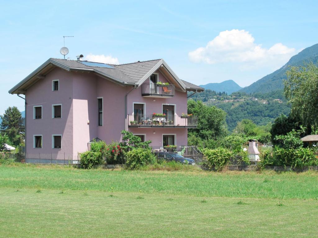 a pink house sitting on top of a field at Apartment Deval-3 by Interhome in Calceranica al Lago