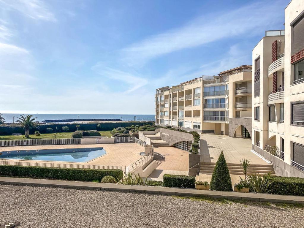 un complexe d'appartements avec une piscine et un bâtiment dans l'établissement Apartment Les Rivages de Rochelongue-3 by Interhome, au Cap d'Agde