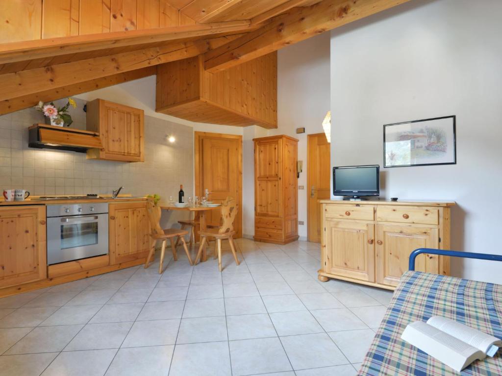 uma cozinha com armários de madeira e uma mesa com cadeiras em Apartment Villa Placidia-2 by Interhome em Campitello di Fassa