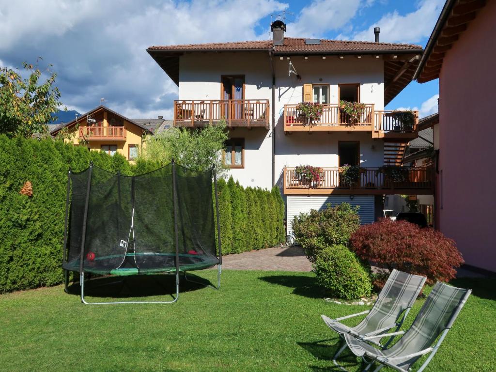 un cortile con 2 sedie a sdraio e un tappeto elastico di Apartment Schmid by Interhome a Caldonazzo