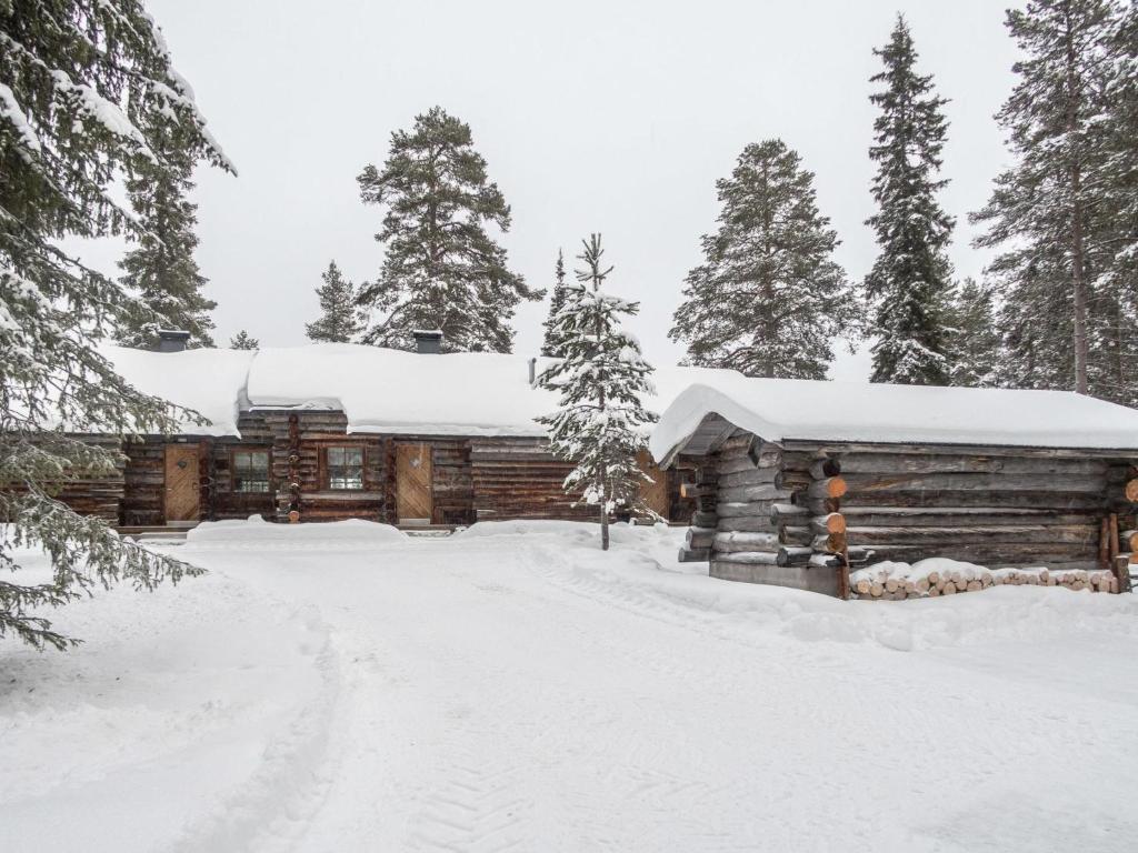 uma cabana de madeira na neve com uma entrada em Holiday Home Saukkokumpu 3 by Interhome em Ruka