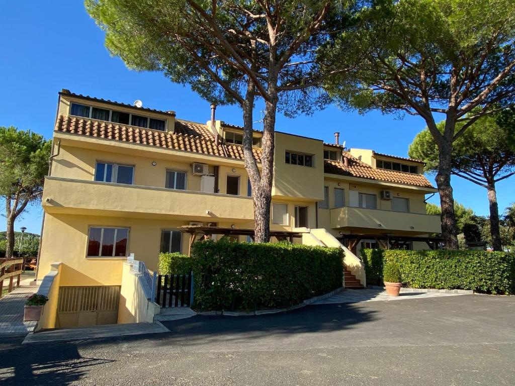 un bâtiment avec des arbres devant un parking dans l'établissement Apartment Riviera 5 by Interhome, à Marina di Cecina