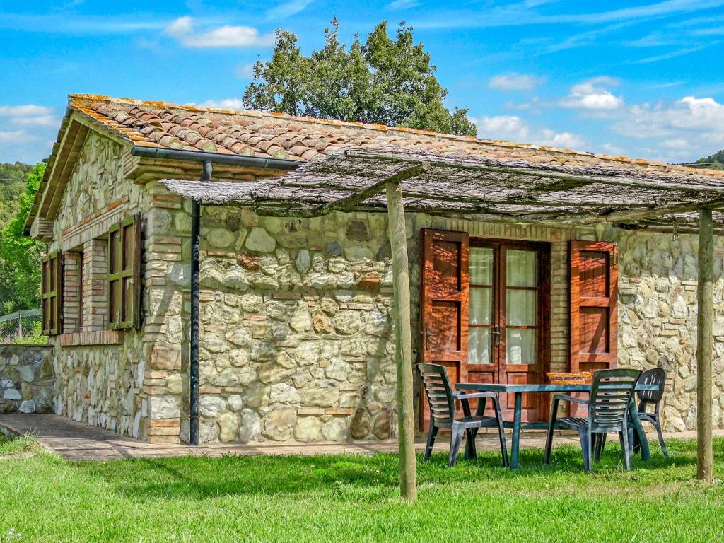 ein Steinhaus mit einem Tisch und Stühlen im Freien in der Unterkunft Holiday Home Ginestra by Interhome in Canneto