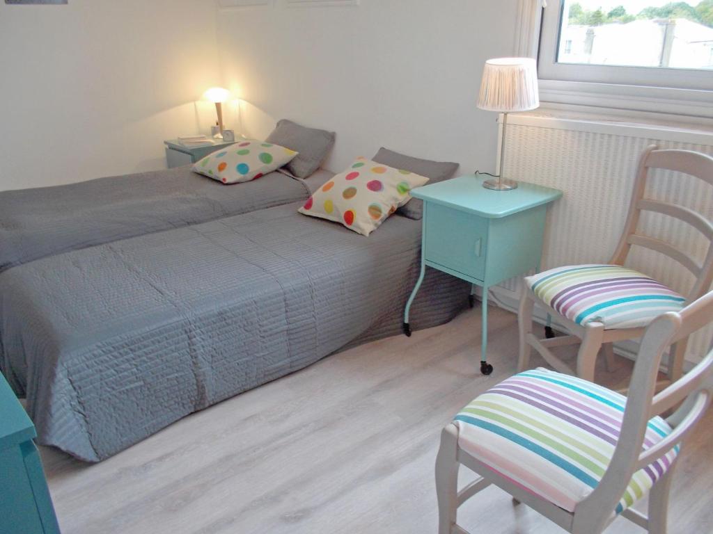 a bedroom with a bed and a table and a chair at Apartment Les Autans by Interhome in Royan