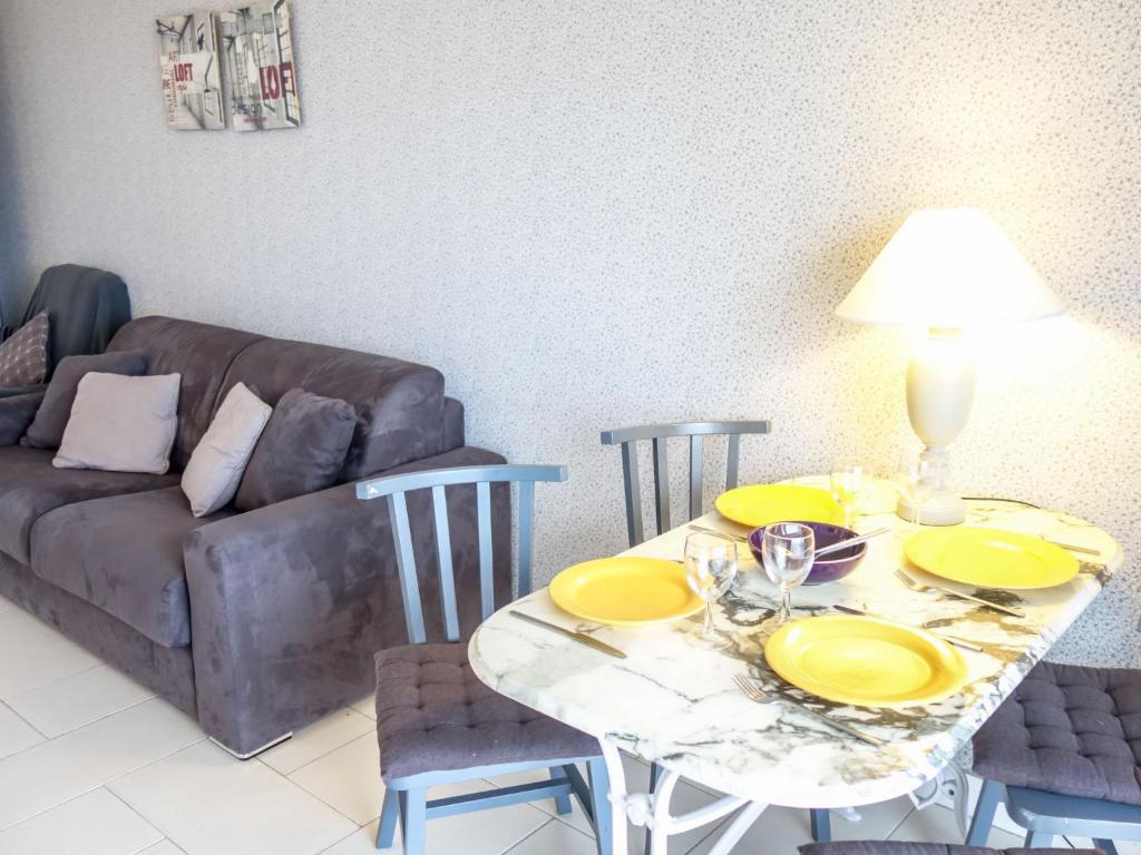 a living room with a table and a couch at Apartment Les Autans by Interhome in Royan