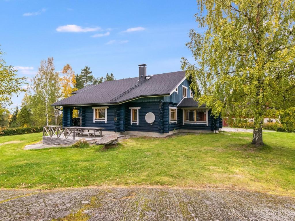 ein blaues Haus mit einem Baum davor in der Unterkunft Holiday Home Honkalinna by Interhome in Kokkosenlahti