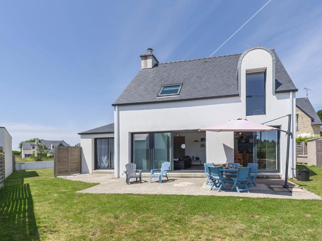 ein weißes Haus mit einer Terrasse mit Stühlen und einem Sonnenschirm in der Unterkunft Holiday Home Pont Neuf by Interhome in Plouharnel