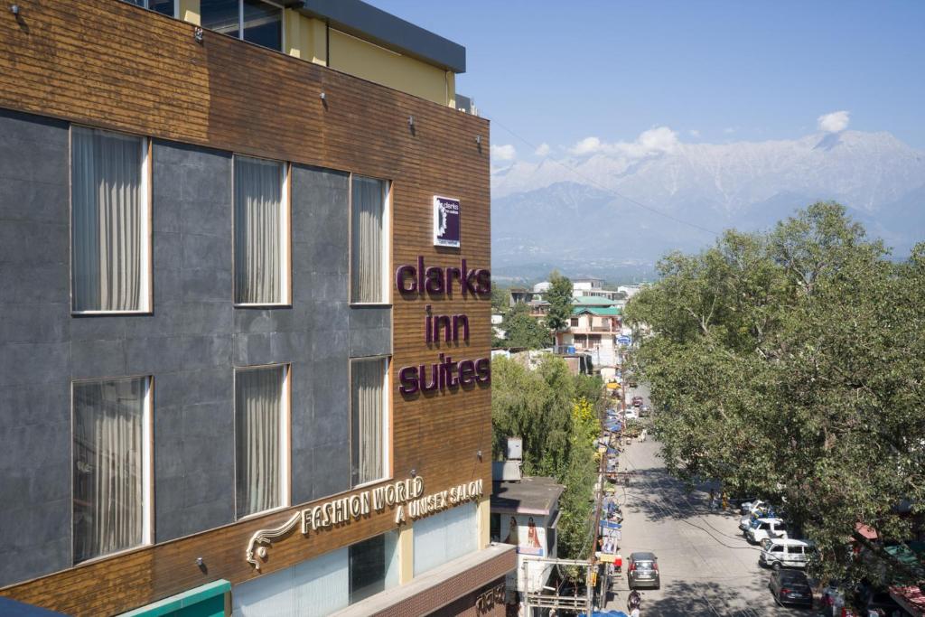a building with a sign on the side of it at Clarks Inn Suites Kangra in Kangra