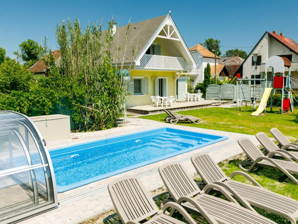 un patio trasero con una piscina con sillas y un tobogán en Holiday Home Sapphire by Interhome en Balatonmáriafürdő