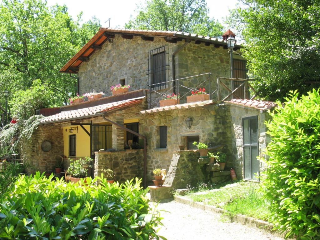 una vista esterna di una casa in pietra con piante di Apartment La Fornace-3 by Interhome a Il Molinaccio