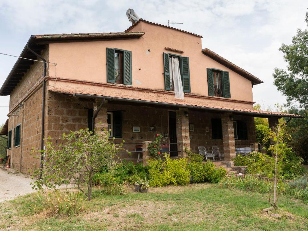 an old brick house with green shutters at Apartment Casale Ai Noccioli-2 by Interhome in Corchiano