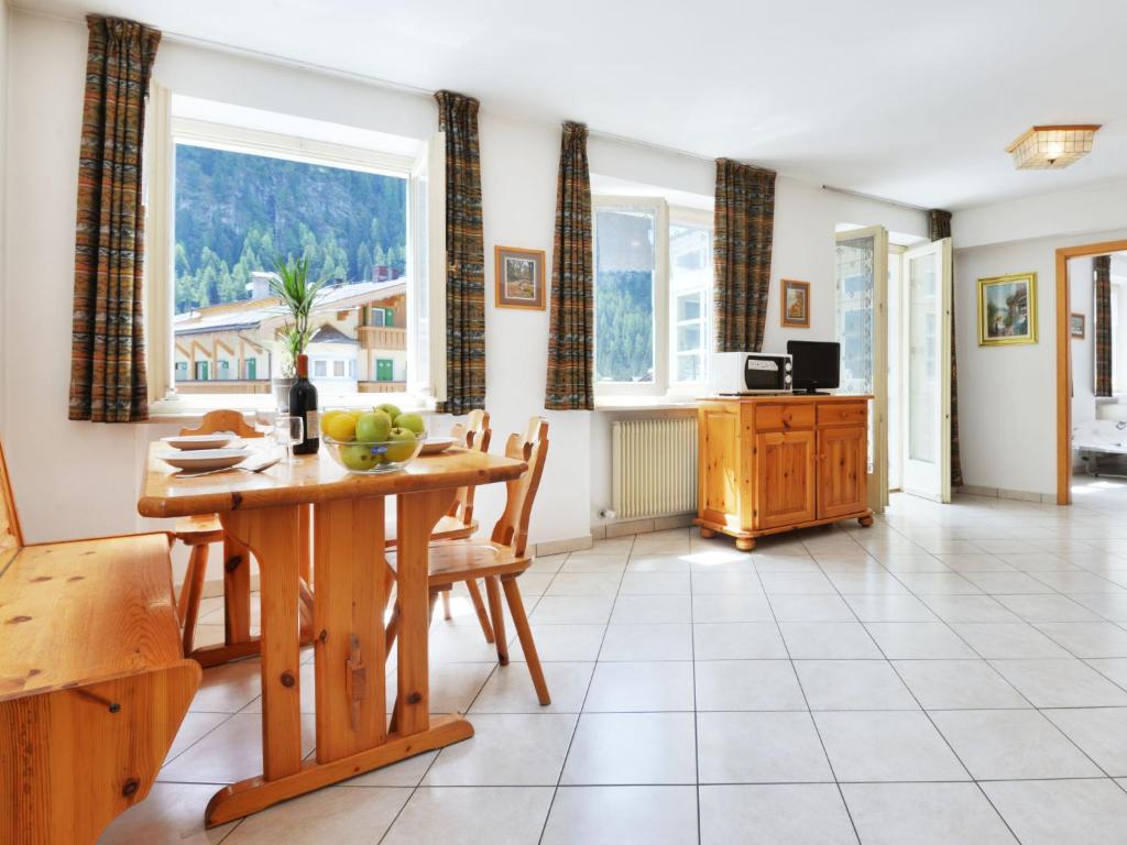 una cucina e una sala da pranzo con tavolo e finestre di Apartment Villa Placidia-7 by Interhome a Campitello di Fassa
