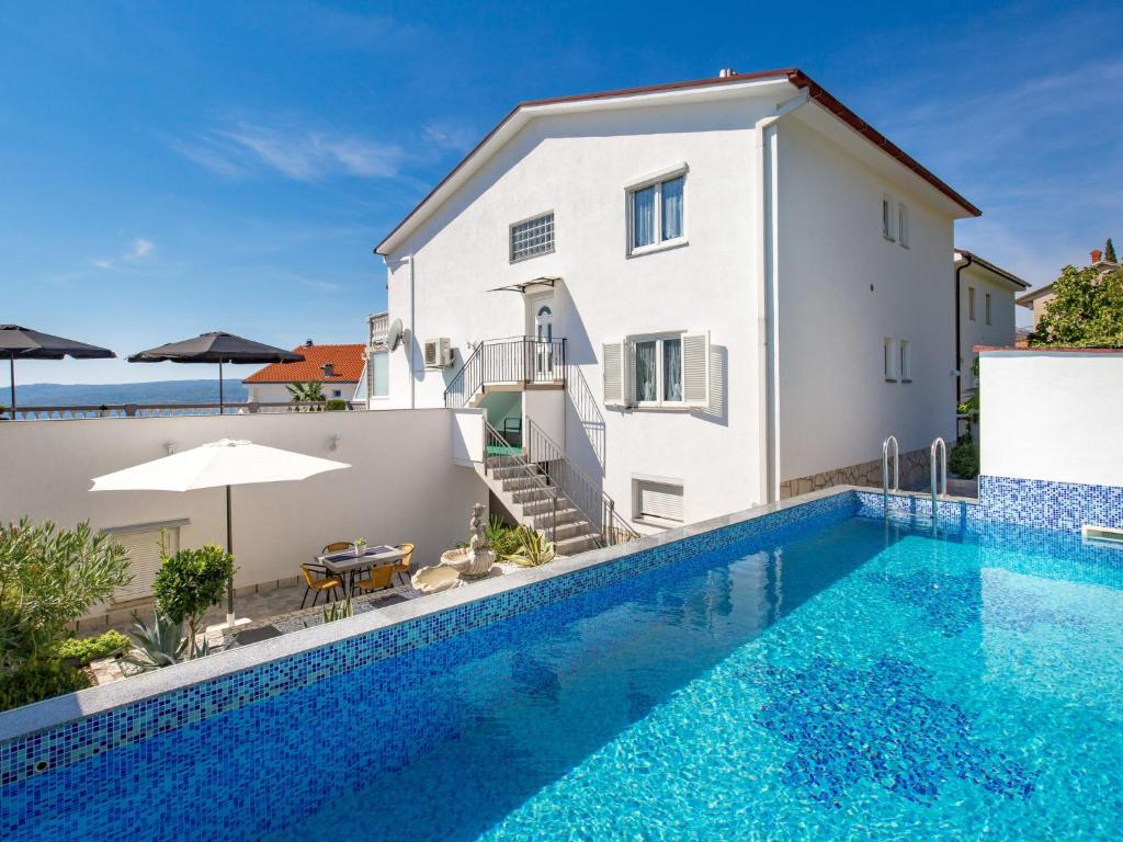 a villa with a swimming pool in front of a house at Apartment Brzic - CKV105 by Interhome in Crikvenica