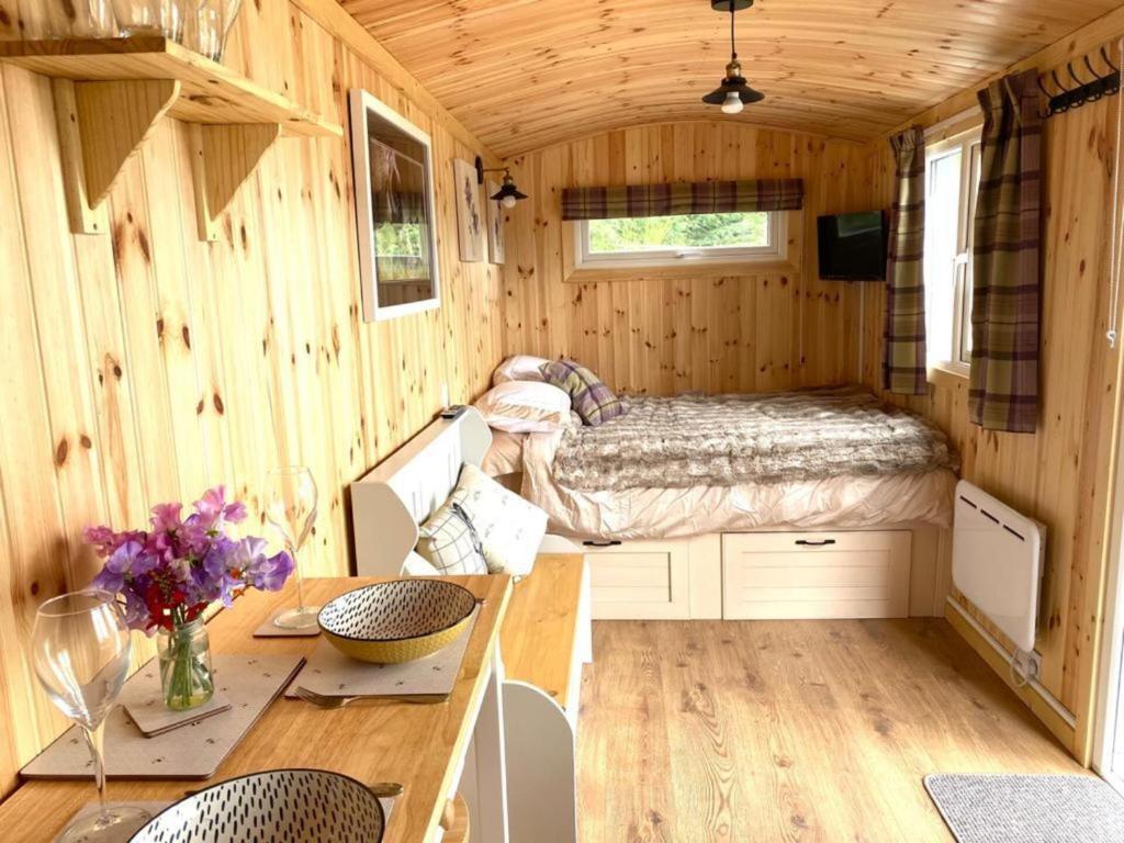 a room with a bed and a table in a tiny house at Remarkable Shepherds Hut in a Beautiful Location in Perth