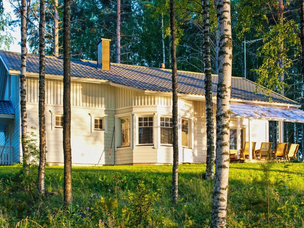 een wit huis met bomen ervoor bij Holiday Home Siika by Interhome in Hiukkajoki