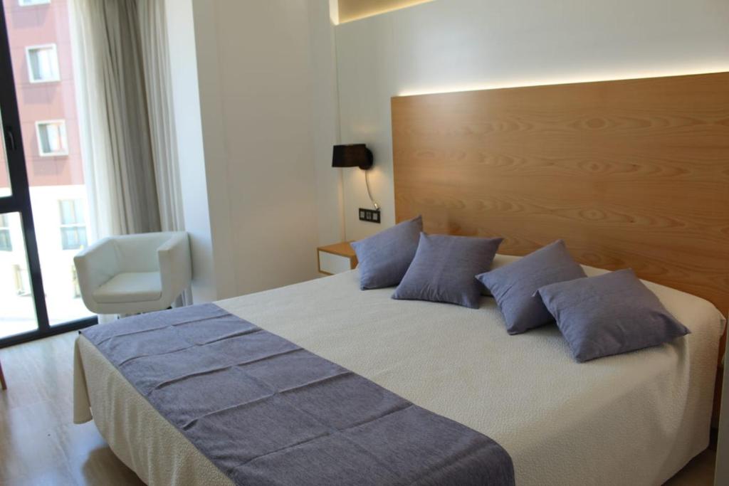 a bedroom with a large bed with blue pillows at Hotel La Noyesa *** Superior in O Grove