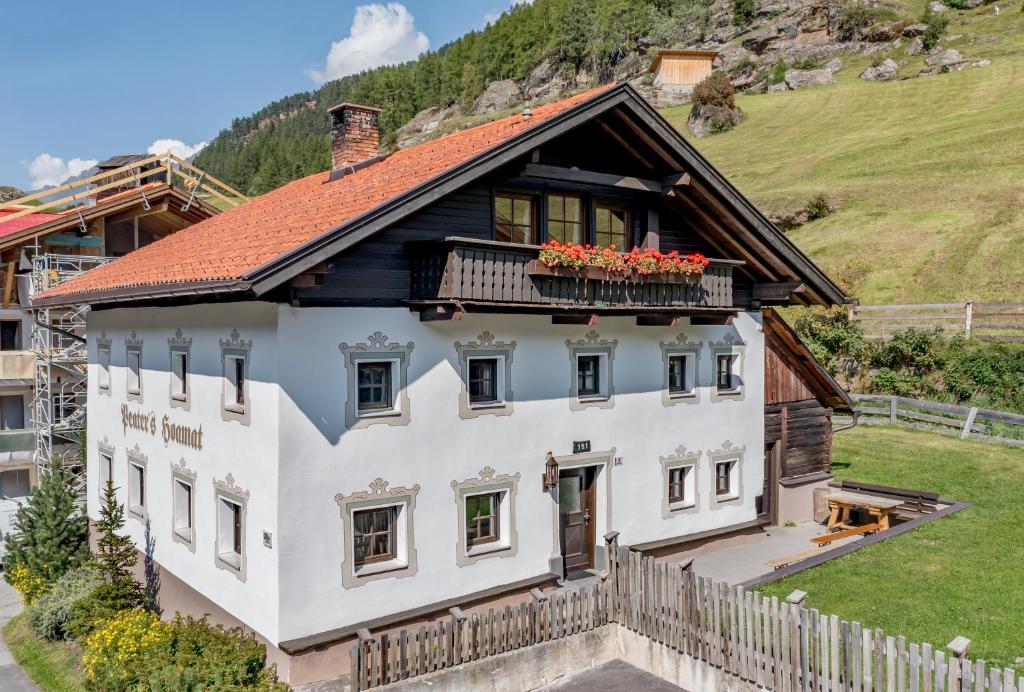 a house in the mountains with flowers on the balcony at Peater's Hoamat in Sölden