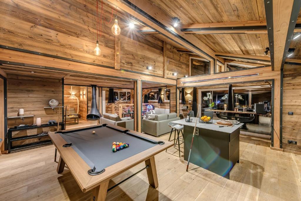 - un billard dans une chambre dotée de murs en bois dans l'établissement Chalet Carte Blanche Merveilles, à Tignes