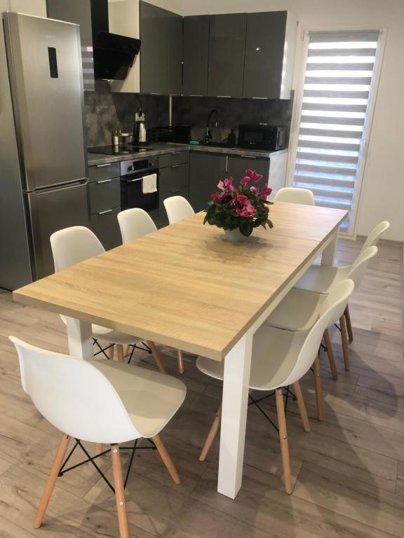 - une cuisine avec une table en bois et des chaises blanches dans l'établissement Apartament Telkom 1, à Milówka
