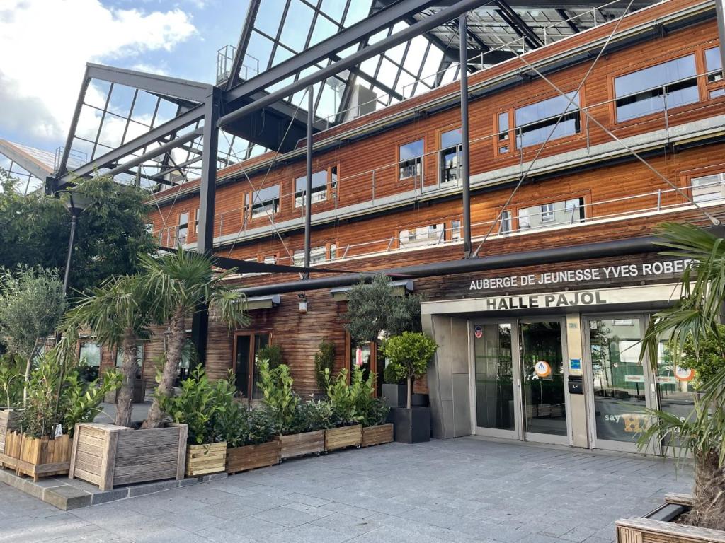 un bâtiment avec des plantes devant lui dans l'établissement Auberge de Jeunesse HI Paris Yves Robert, à Paris