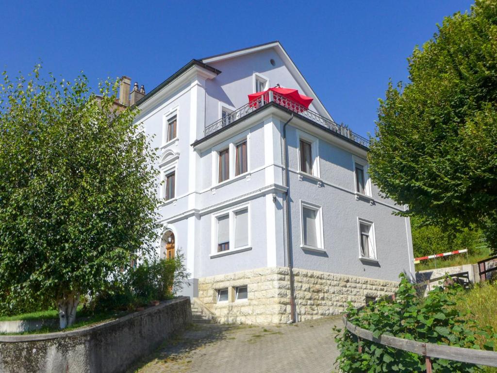 - un bâtiment blanc avec un balcon rouge au-dessus dans l'établissement Apartment Maison de Maître by Interhome, à Tramelan