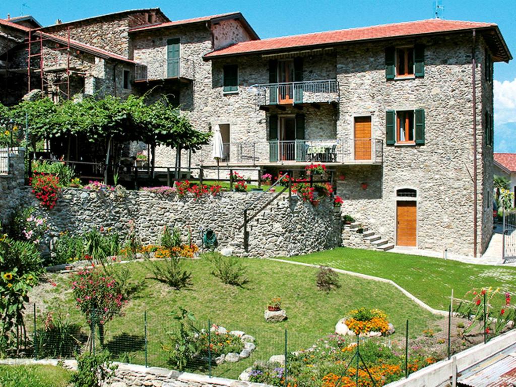ein großes Steinhaus mit Garten davor in der Unterkunft Apartment Ghiano by Interhome in Cremia