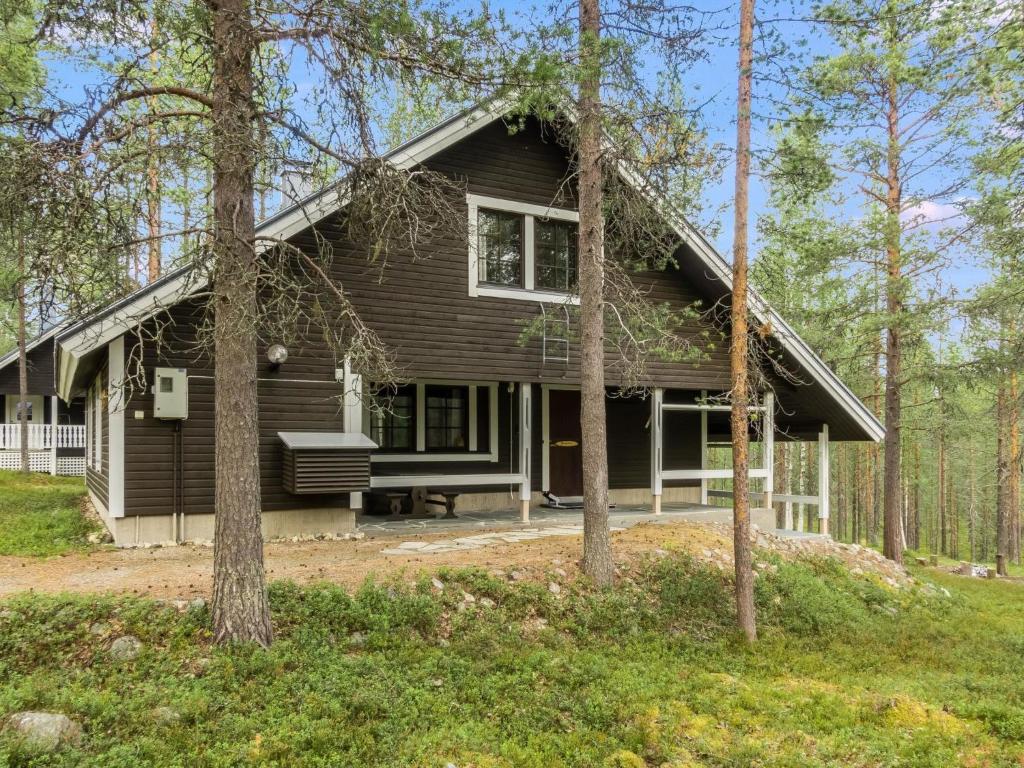 a house in the woods with a bench in front of it at Holiday Home Kevinlevi by Interhome in Sirkka