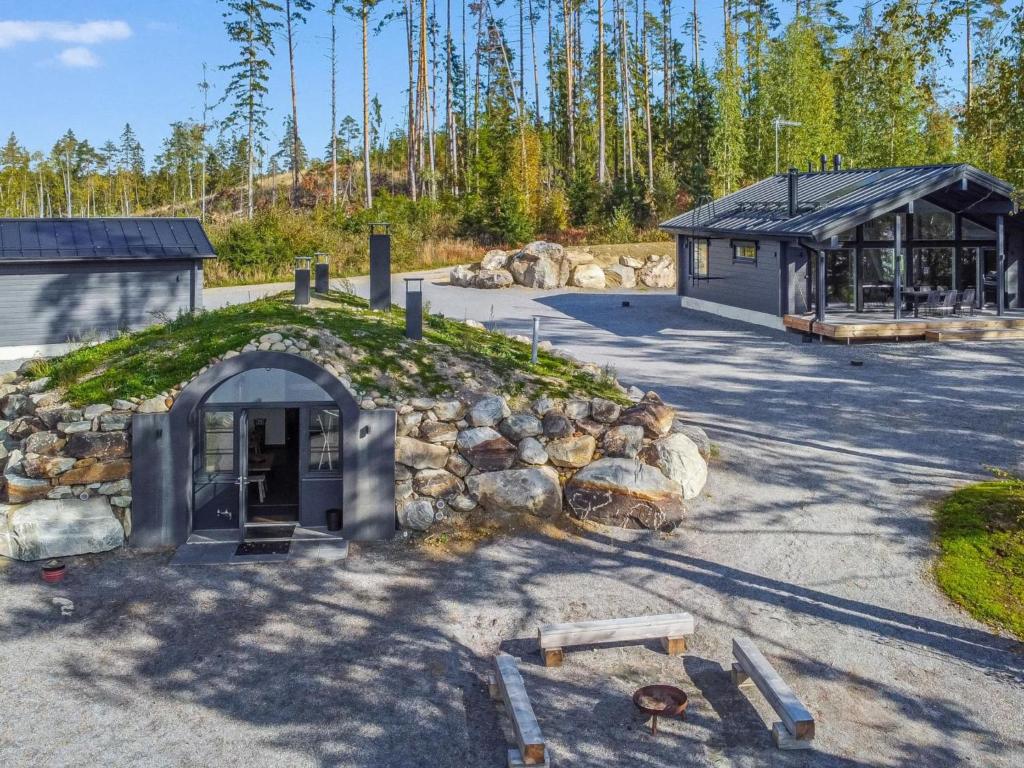 a building with a grassy roof next to a stone wall at Holiday Home Aurinkoranta by Interhome in Padasjoki
