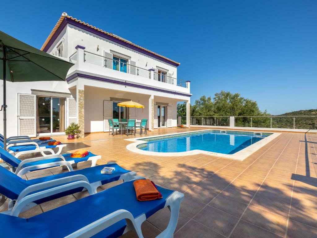 uma villa com uma piscina e espreguiçadeiras azuis em Holiday Home Joaquim by Interhome em Estoi